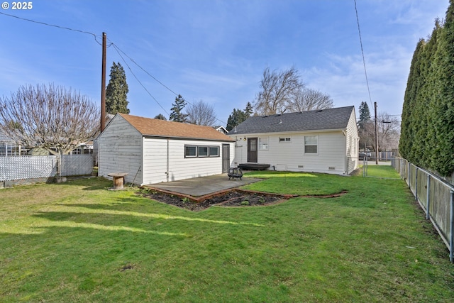 rear view of property featuring a yard, an outdoor structure, and a patio