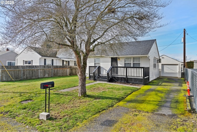 view of front facade with a garage, an outdoor structure, a front yard, and a deck