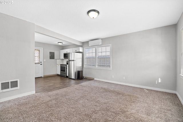 unfurnished living room featuring dark carpet, electric panel, and a wall unit AC