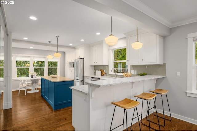 7928 SE 21st Ave, Portland, OR 97202 - kitchen featuring blue cabinetry, high end refrigerator, crown molding, white cabinets, and healthy amount of natural light