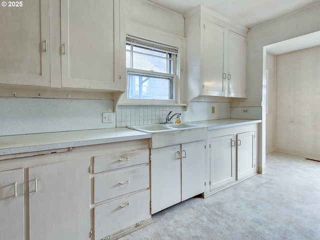 kitchen featuring white cabinetry, visible vents, a sink, light countertops, and decorative backsplash