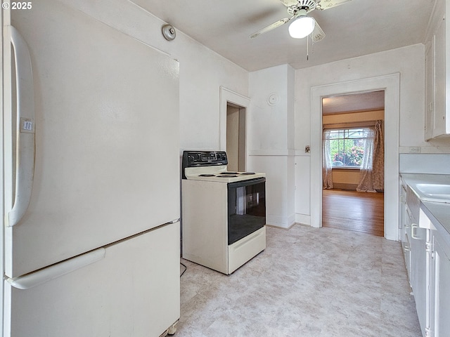 kitchen featuring white cabinets, a sink, light countertops, a ceiling fan, and white appliances