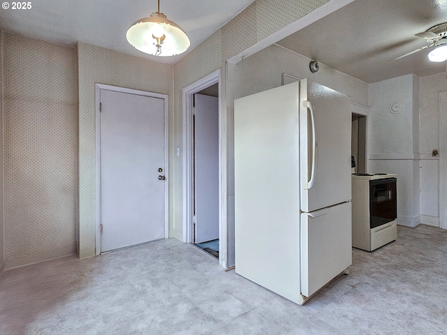 interior space featuring a ceiling fan, white appliances, light colored carpet, and wallpapered walls