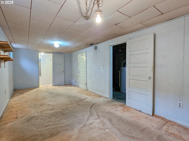finished below grade area with baseboards, carpet, and water heater