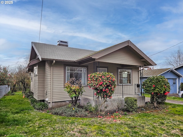 view of front of home featuring a porch, a chimney, a front yard, and fence
