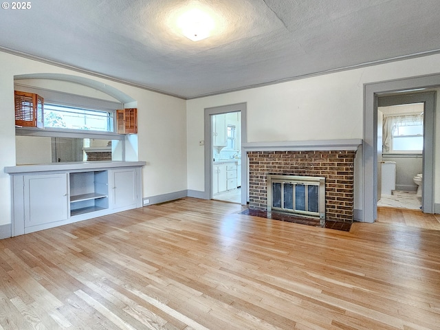 unfurnished living room with baseboards, plenty of natural light, and wood finished floors