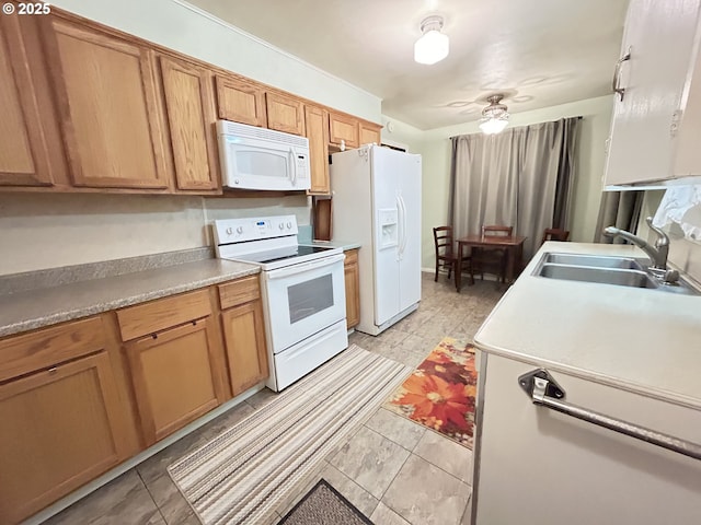 kitchen with brown cabinetry, white appliances, light countertops, and a sink