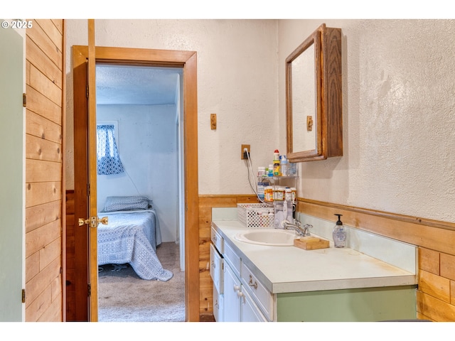 bathroom featuring vanity and a textured wall