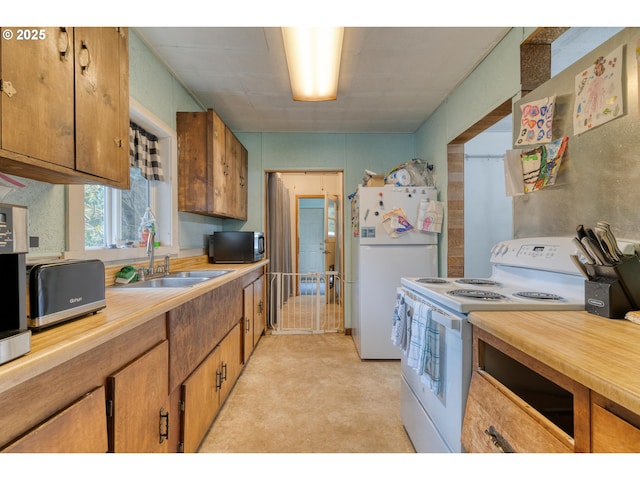 kitchen with brown cabinets, a sink, white appliances, light countertops, and a toaster