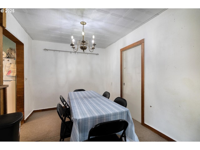 dining room featuring carpet floors, baseboards, and an inviting chandelier