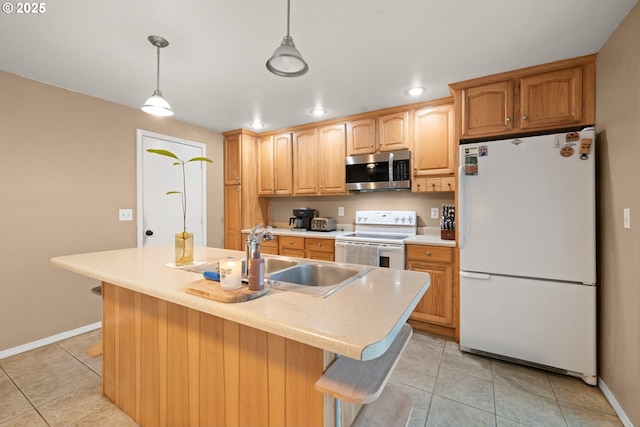 kitchen featuring sink, white appliances, light tile patterned floors, hanging light fixtures, and an island with sink