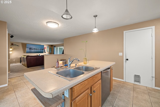 kitchen featuring pendant lighting, sink, dishwasher, and light tile patterned flooring