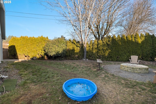 view of pool featuring a yard and a fire pit