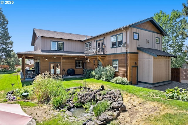rear view of property with a yard, a patio, fence, and a balcony
