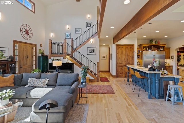 living area with stairway, a high ceiling, and recessed lighting