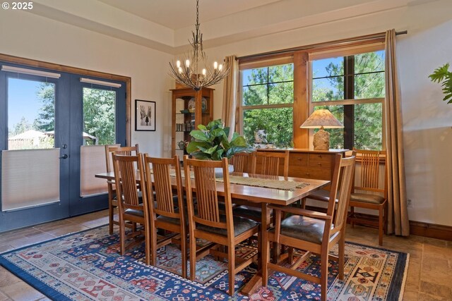 dining area with a chandelier and french doors