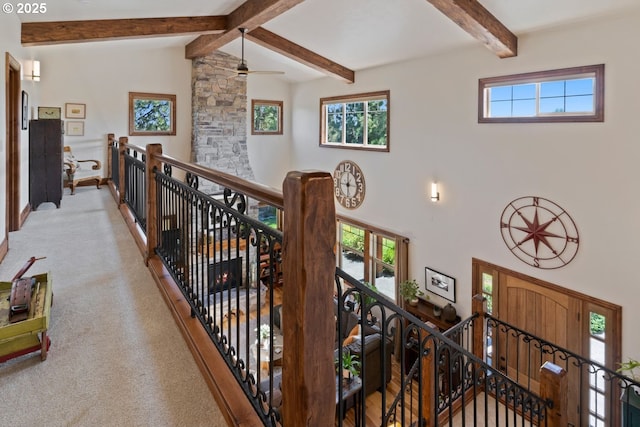 hallway with high vaulted ceiling, light colored carpet, beam ceiling, and an upstairs landing