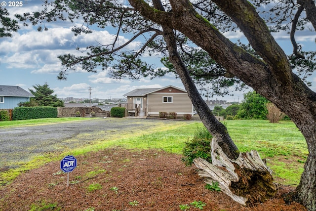 view of front facade with a front yard and fence