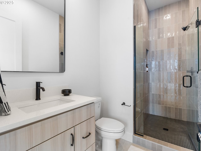 bathroom featuring toilet, vanity, and an enclosed shower