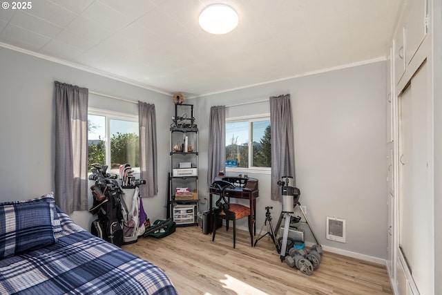 bedroom with light wood-style flooring, multiple windows, and crown molding