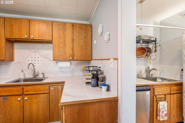 kitchen with brown cabinetry, a sink, and dishwasher