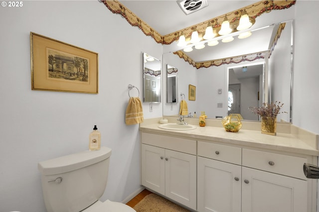 bathroom featuring toilet, visible vents, and vanity