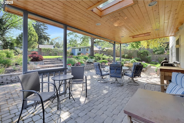 view of patio / terrace featuring outdoor dining area, an outdoor structure, a fenced backyard, and a storage shed