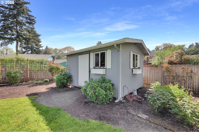 view of outdoor structure featuring a fenced backyard and an outbuilding