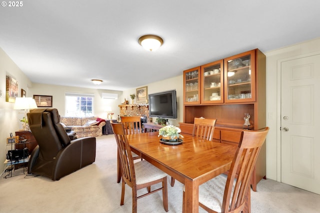 dining area with a wall unit AC and light colored carpet