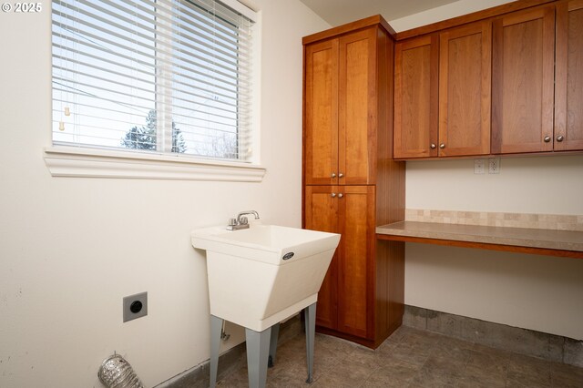 laundry area with cabinets, electric dryer hookup, and sink