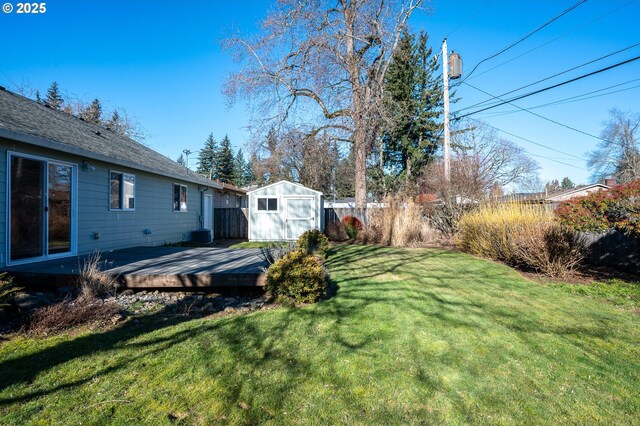 view of yard with a wooden deck, central AC, and a storage shed