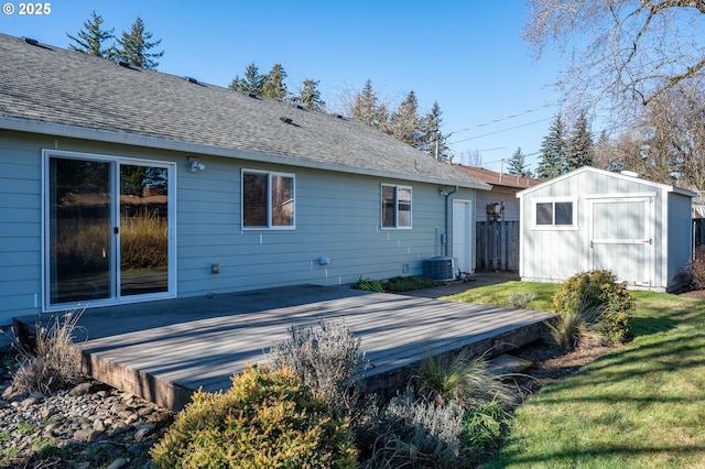 back of house with a wooden deck, a storage shed, a lawn, and cooling unit