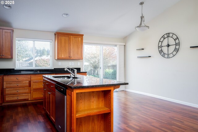 kitchen featuring sink, decorative light fixtures, vaulted ceiling, dark hardwood / wood-style flooring, and an island with sink