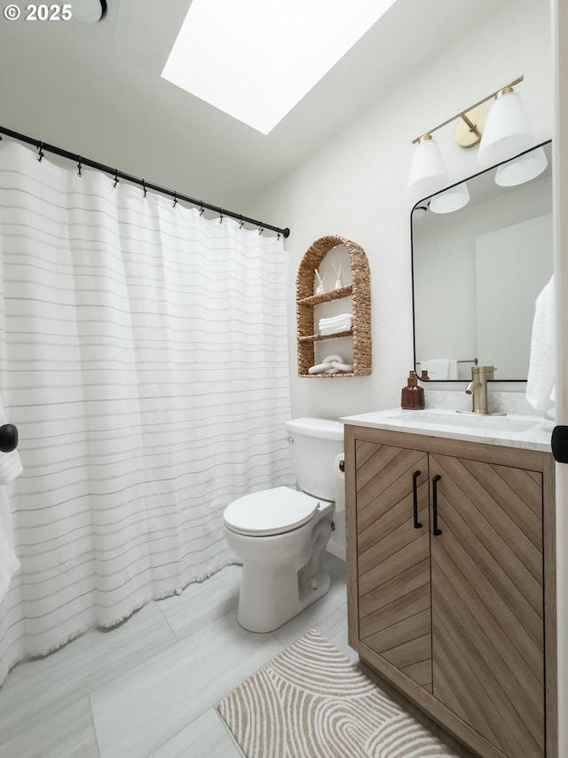 full bath with toilet, a shower with shower curtain, a skylight, tile patterned flooring, and vanity