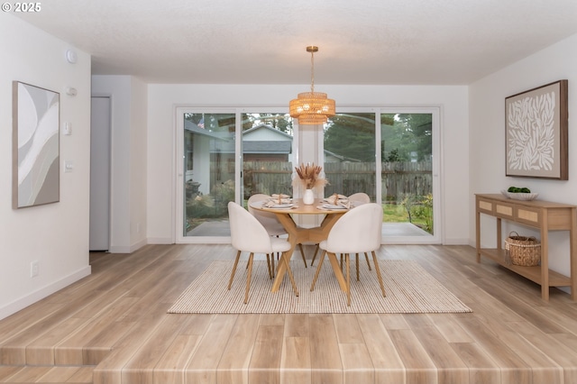 4045 Spruce St, Florence, OR 97439 - dining space with light wood-style floors, a chandelier, and baseboards
