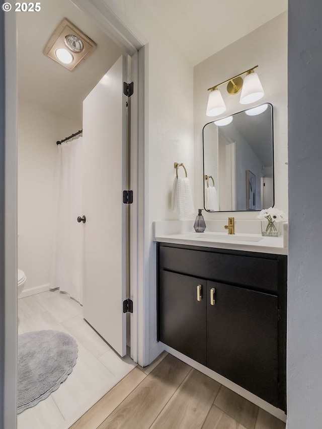 bathroom featuring vanity, curtained shower, and toilet