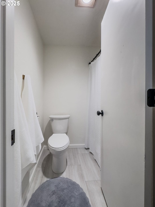 bathroom with toilet and baseboards