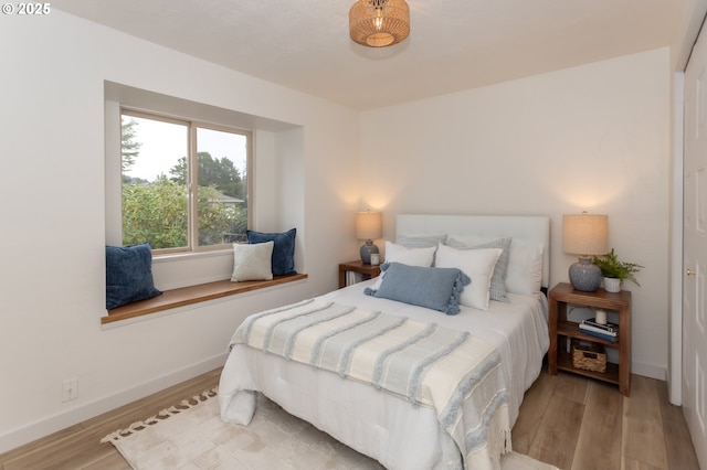 bedroom with baseboards and wood finished floors