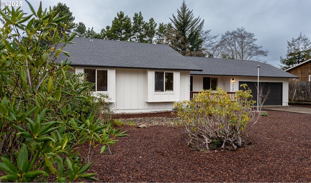 ranch-style home featuring driveway, a garage, and roof with shingles