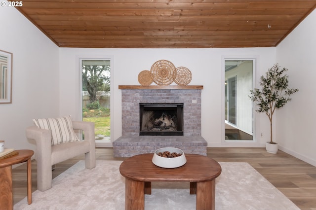 living area with wood finished floors, lofted ceiling, and wooden ceiling