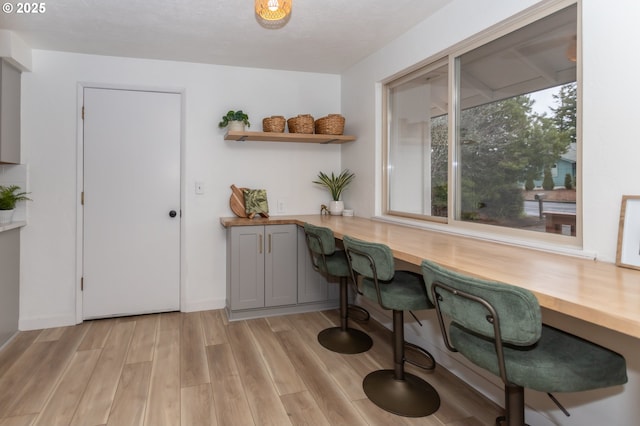 home office with light wood-style flooring and built in study area