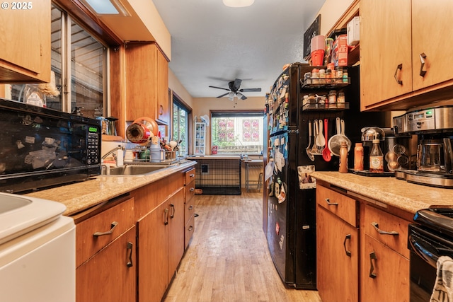 kitchen with ceiling fan, stove, sink, and light hardwood / wood-style floors