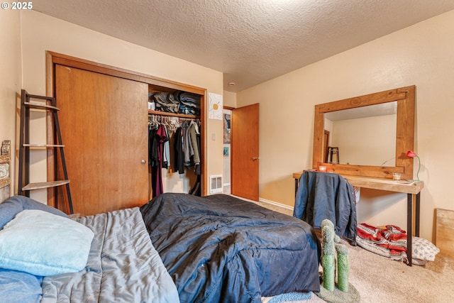 bedroom featuring carpet flooring, a closet, and a textured ceiling