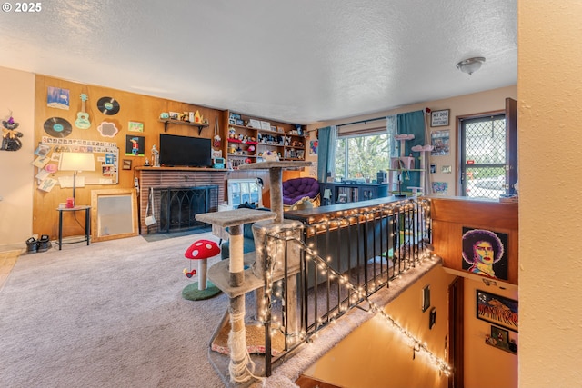 carpeted living room with a brick fireplace, a textured ceiling, and wood walls