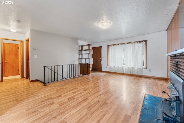 unfurnished living room with a textured ceiling and light wood-type flooring