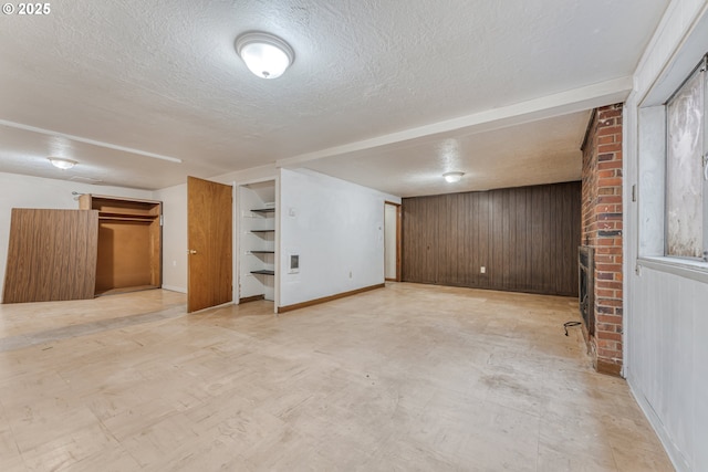 basement featuring wooden walls and a textured ceiling