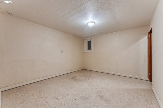 unfurnished room with electric panel and a textured ceiling