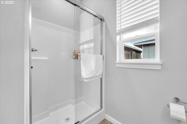 full bath featuring baseboards and a shower stall