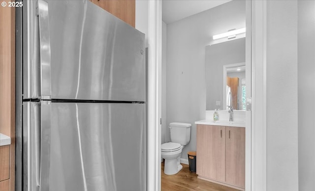bathroom featuring vanity, toilet, and wood finished floors