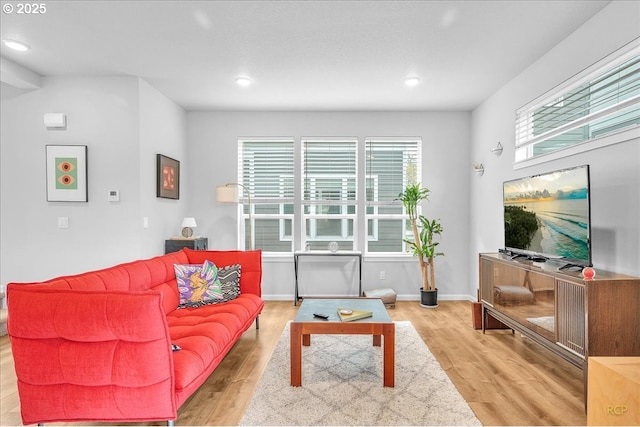 living area with wood finished floors, baseboards, and recessed lighting